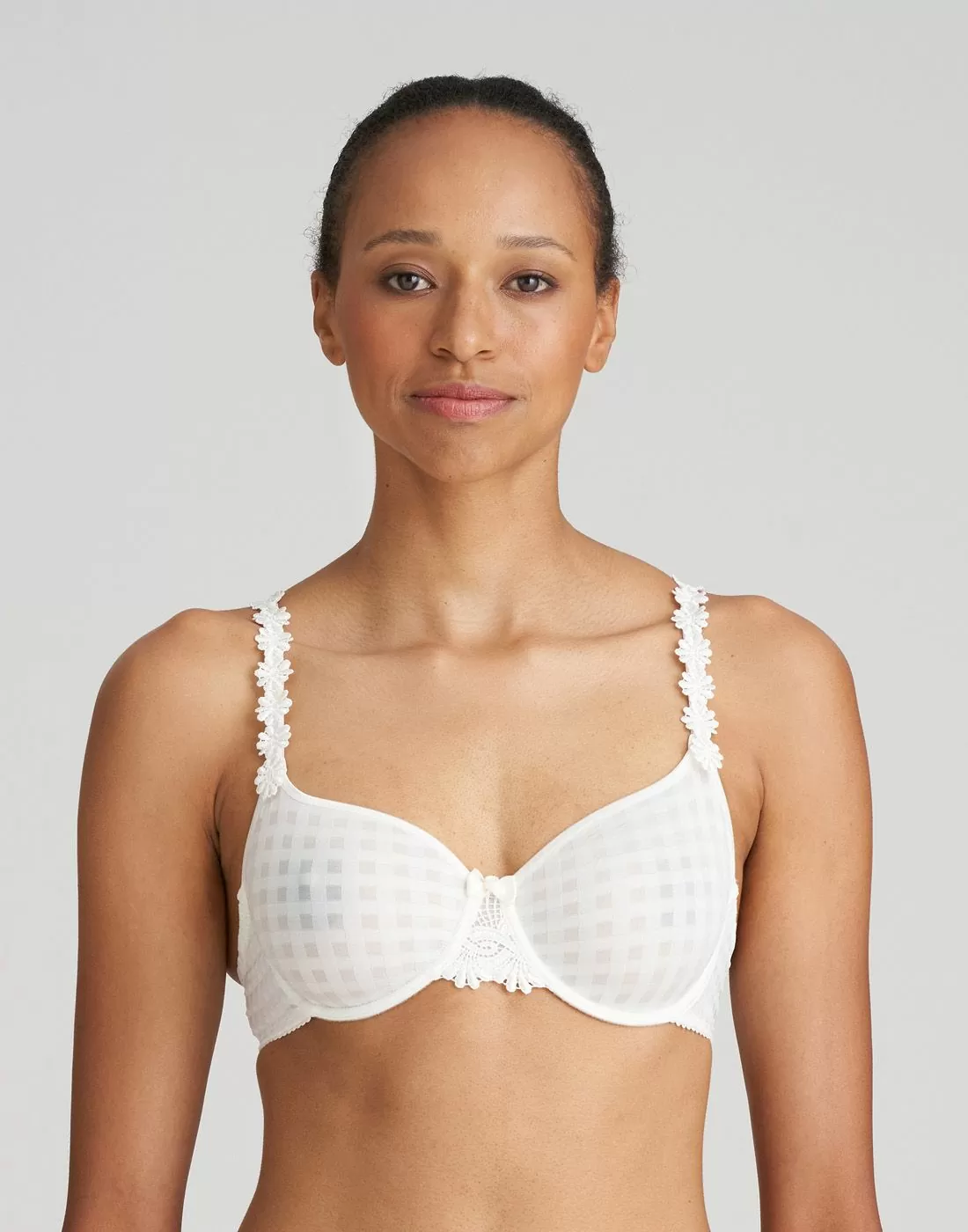 Mørk jente med hvit uvattert BH med blomster og rutete mønster