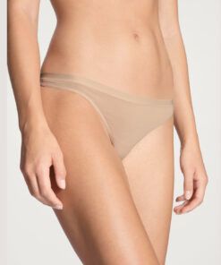 jente i beige stringtruse i bomull