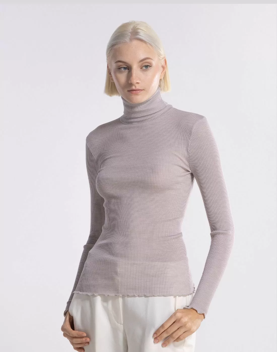 blond jente i grå høyhalset polo genser av ull og silke