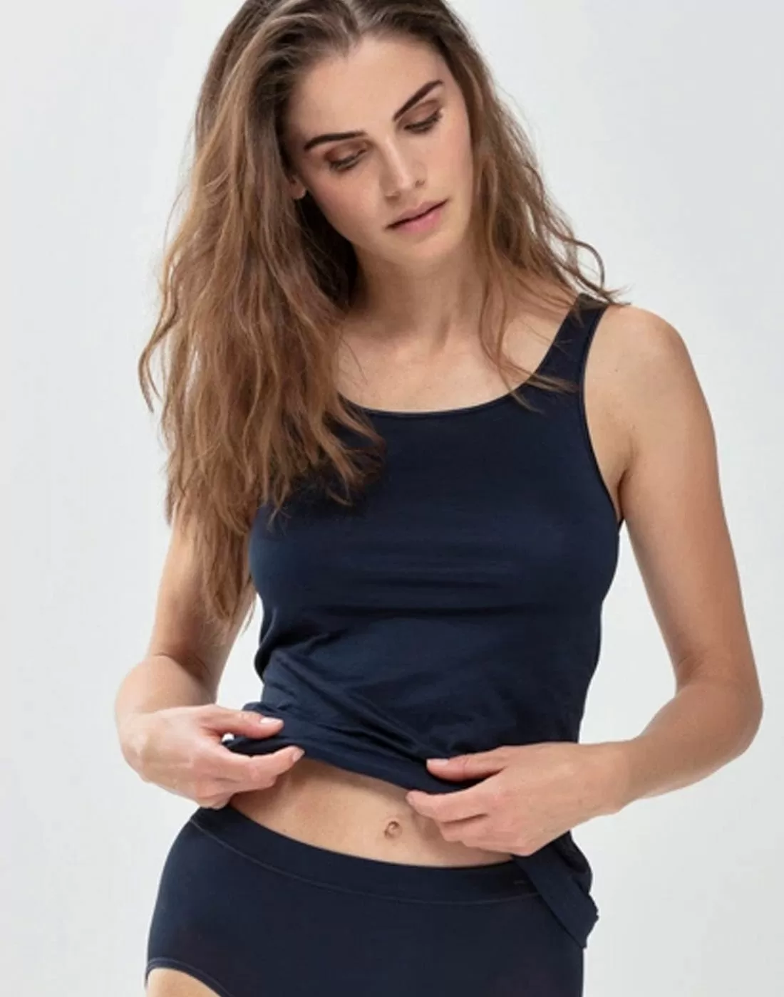 jente med brunt langt hår i mørkeblå tank topp fra mey