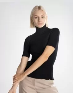 blond kvinne i svart høyhalset t-skjorte av ull og silke