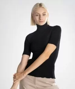 blond kvinne i svart høyhalset t-skjorte av ull og silke