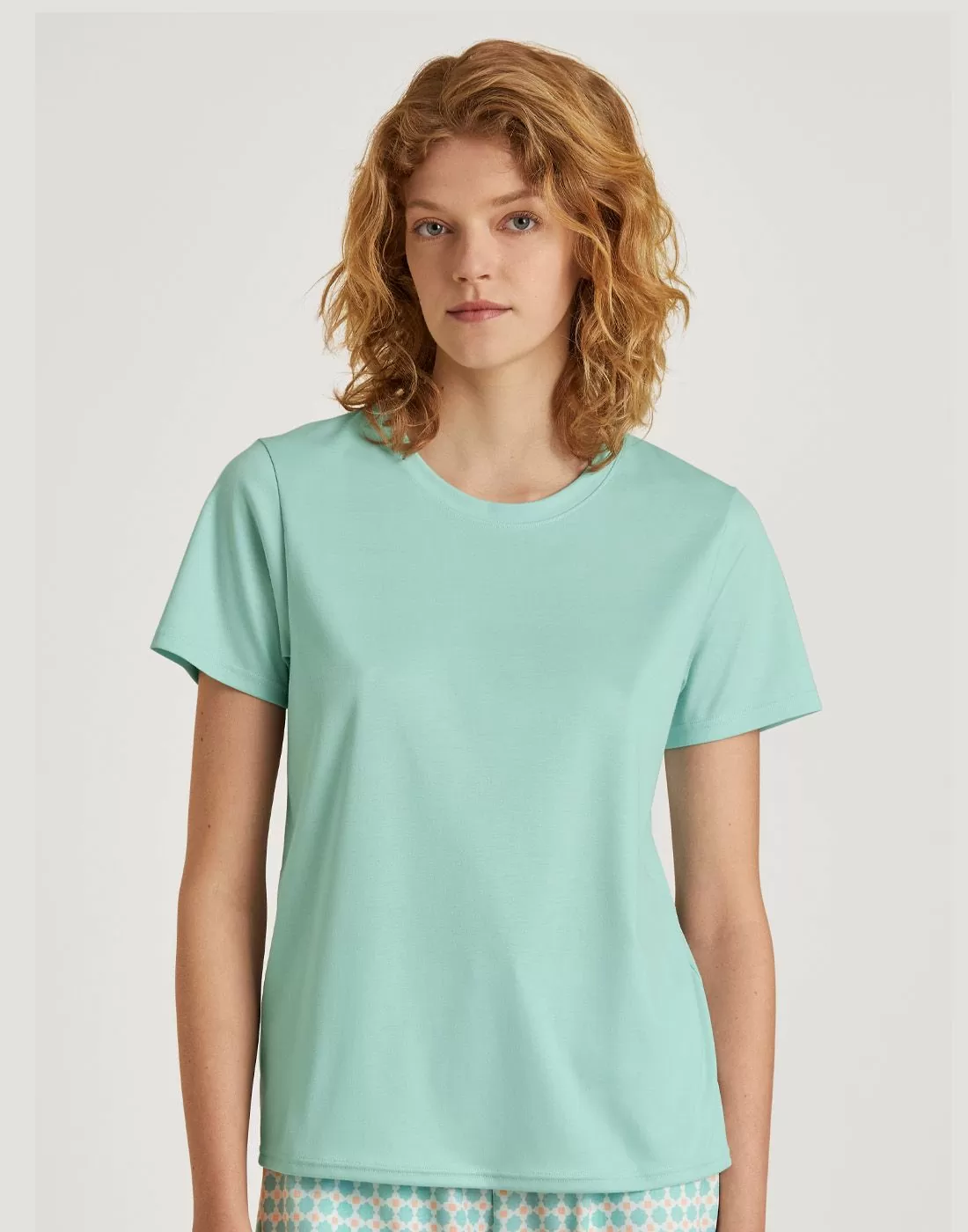 rødhåret jente poserer med lysegrønn t-skjorte fra Calida
