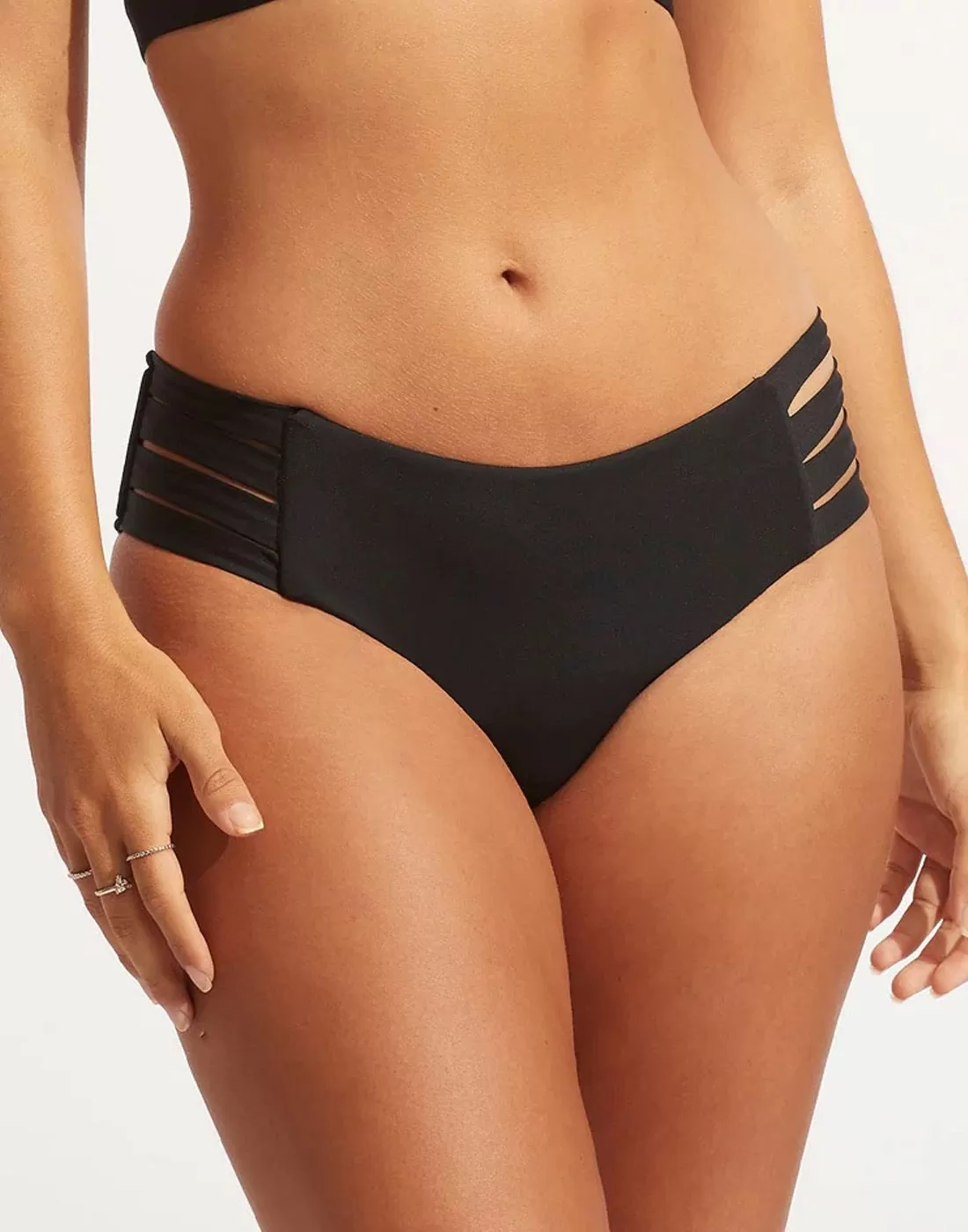 kvinne i svart bikinitruse med stropper på sidene