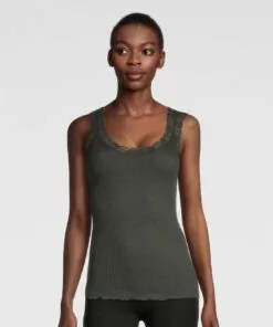 kvinne i mørkegrønn ull og silke singlet med blonde