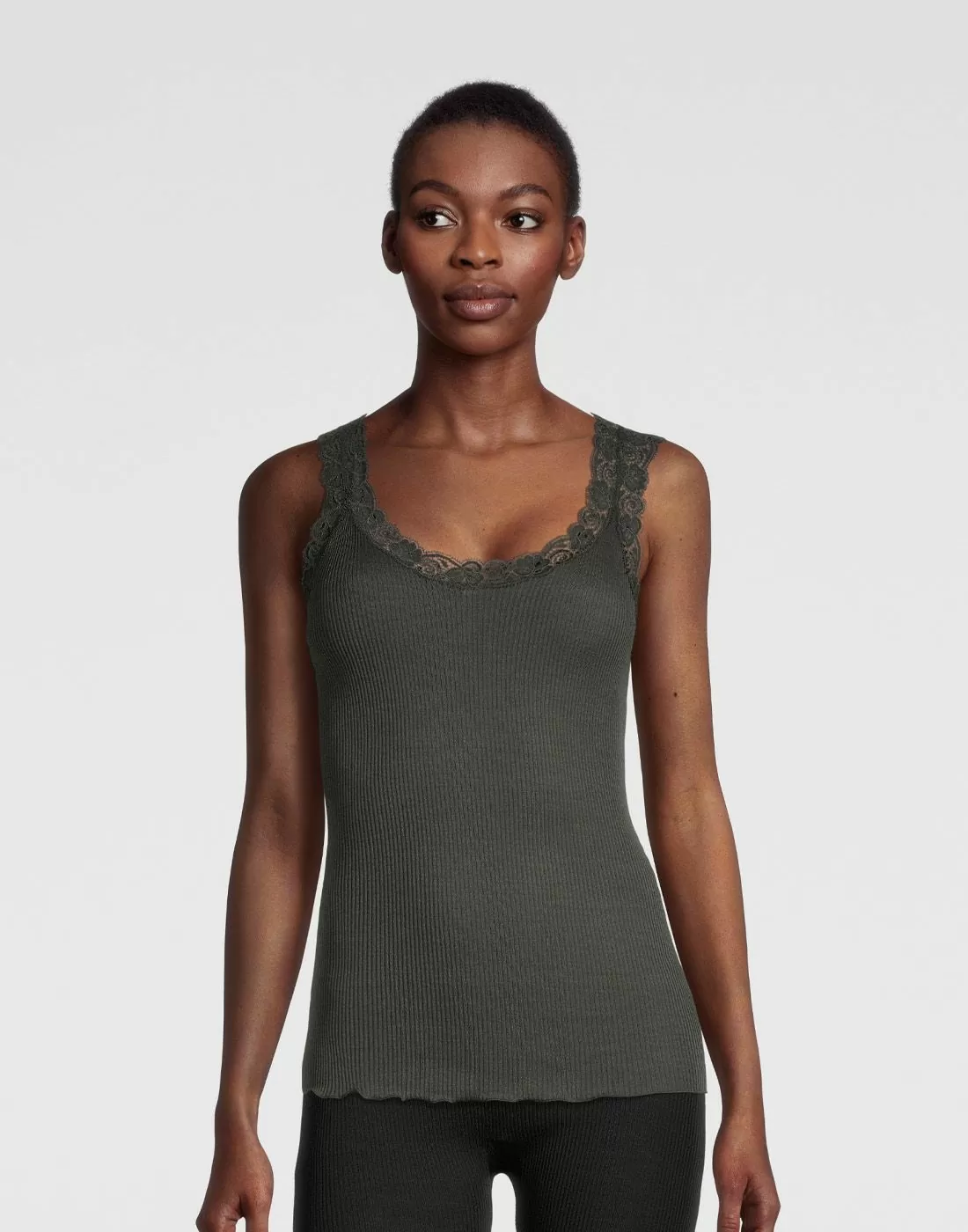 kvinne i mørkegrønn ull og silke singlet med blonde