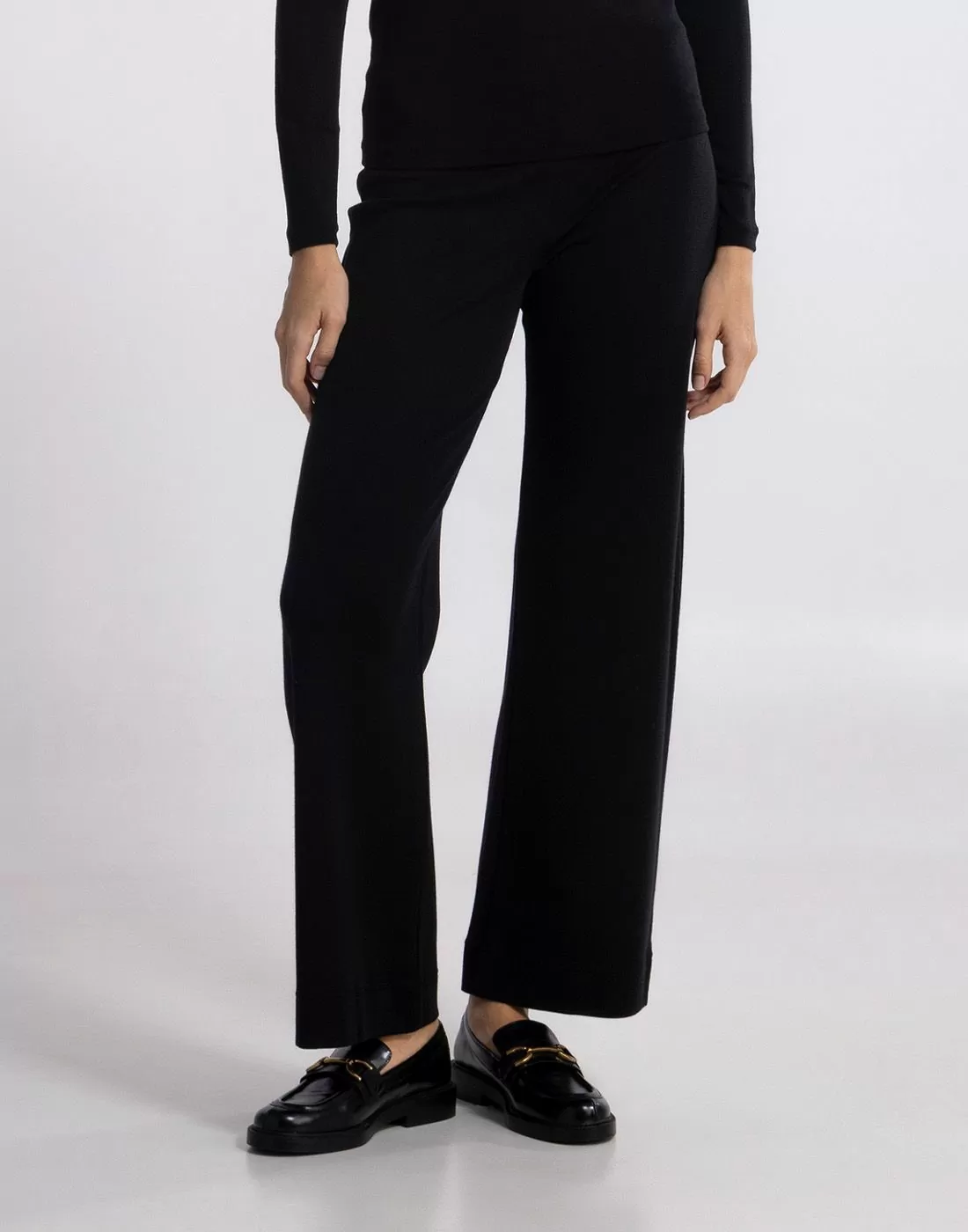 kvinne med svart ull og silke kose bukse