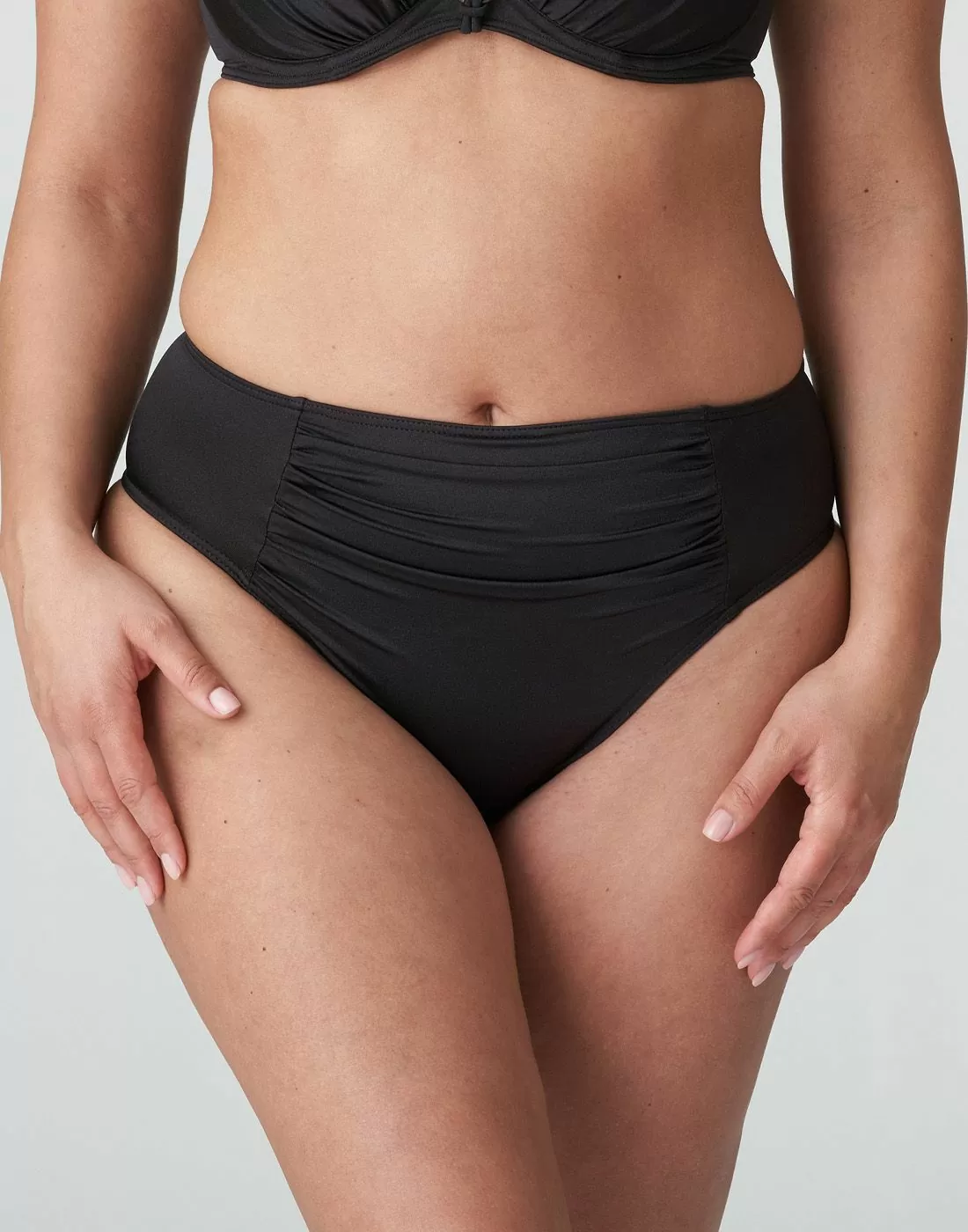 Kvinne med mørk brun high waist bikinitruse