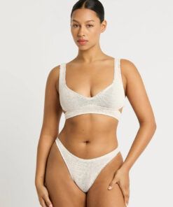 mørk kvinne i hvit bikini med tekstur i stoffet