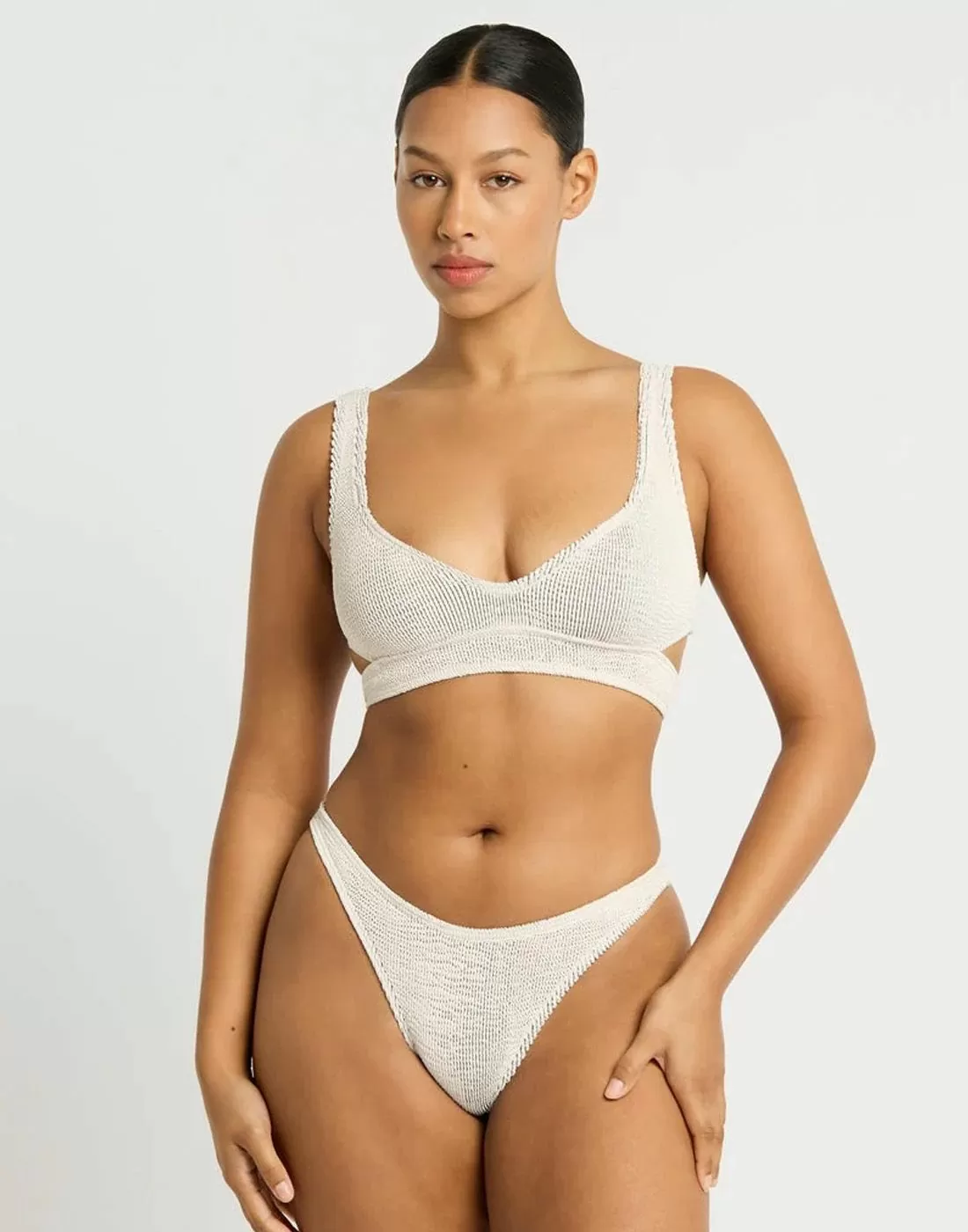 mørk kvinne i hvit bikini med tekstur i stoffet