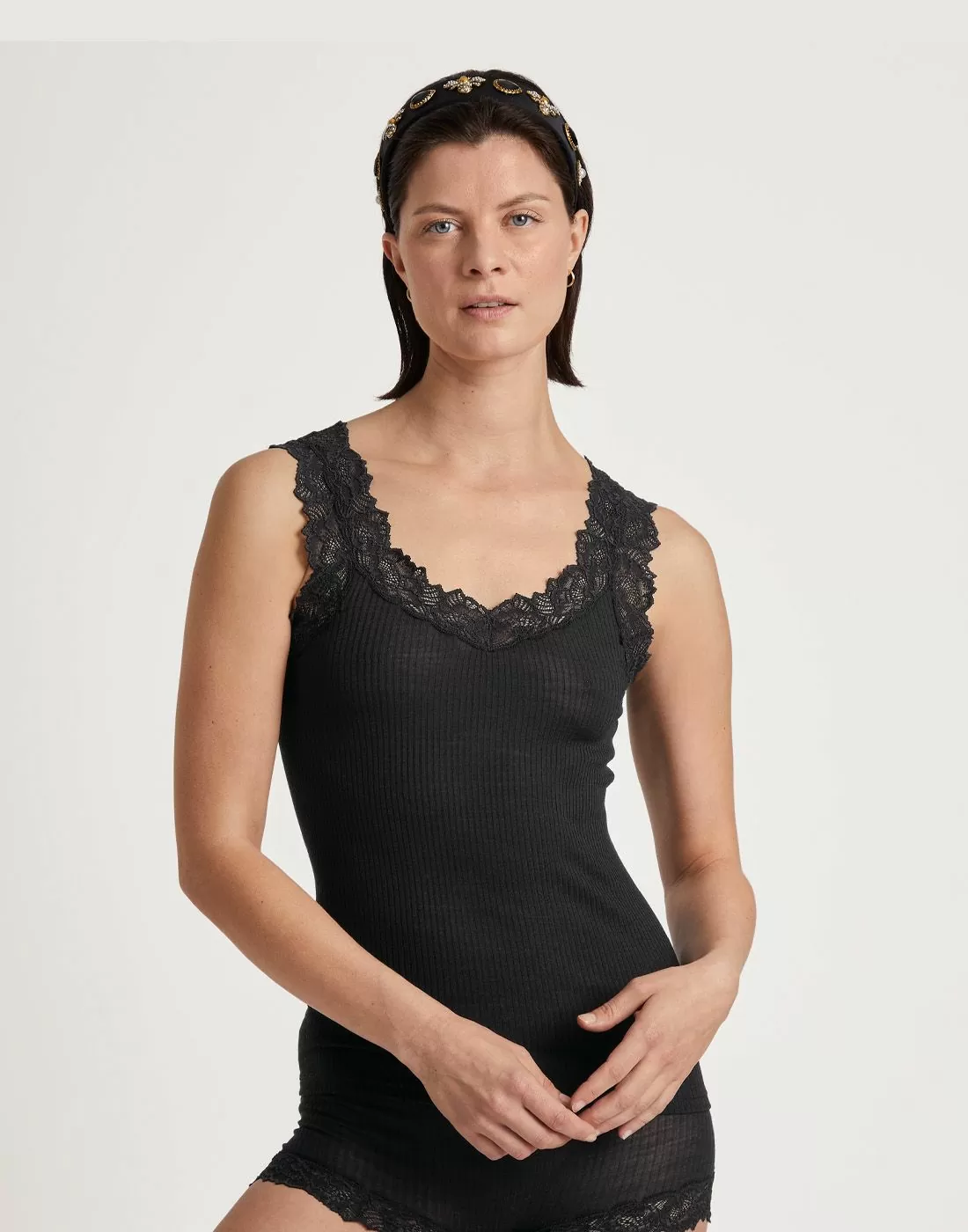 kvinne i svart singlet av ull og silke med blonder