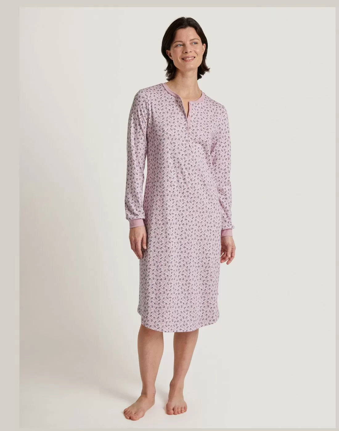 kvinne i langermet rosa mønstret kjole