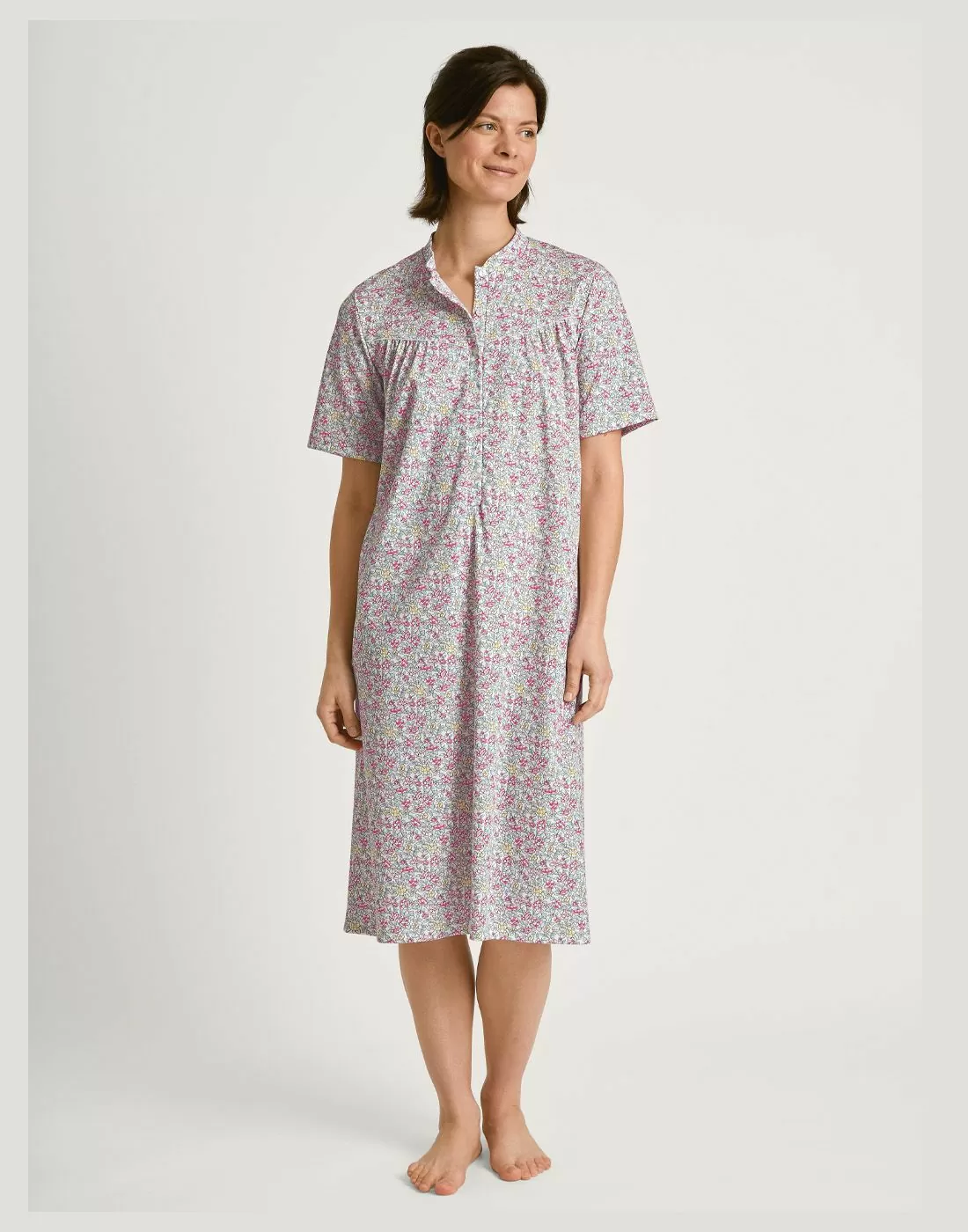 mørk kvinne i lang blomstrete nattkjole i bomull