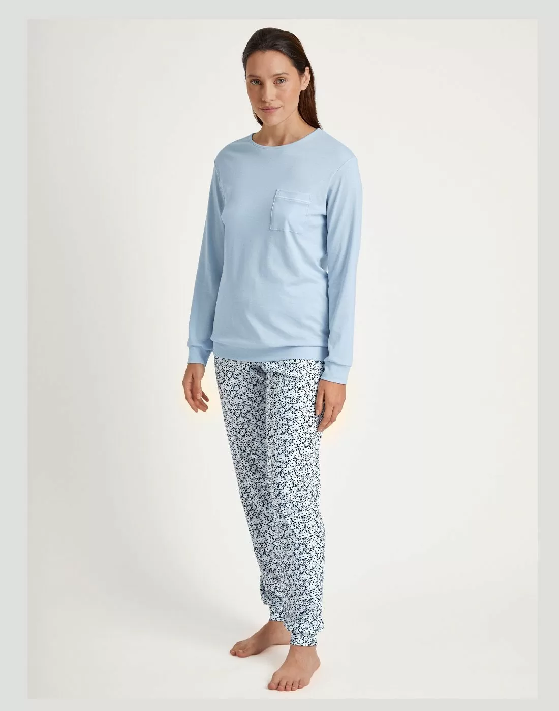 kvinne med blå genser og mønstret bukse pysjamas