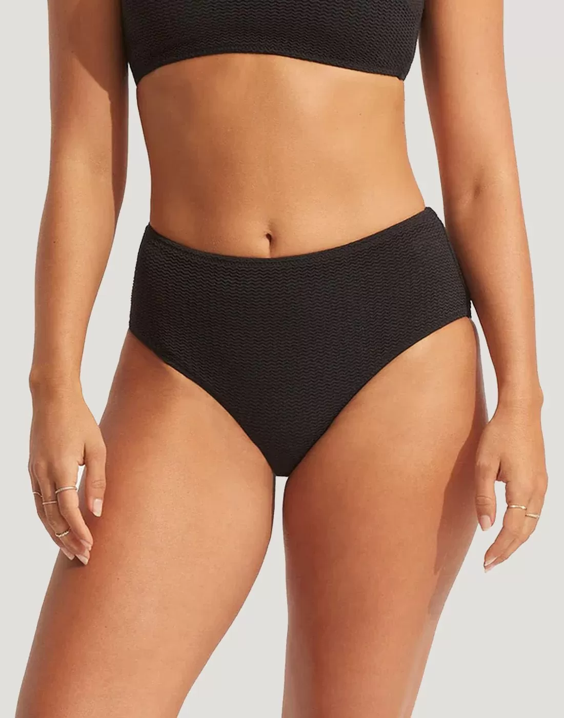 Jente i svart high waist ribbestrikket bikinitruse