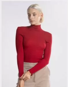 blond kvinne i rød høyhalset genser av ull og silke