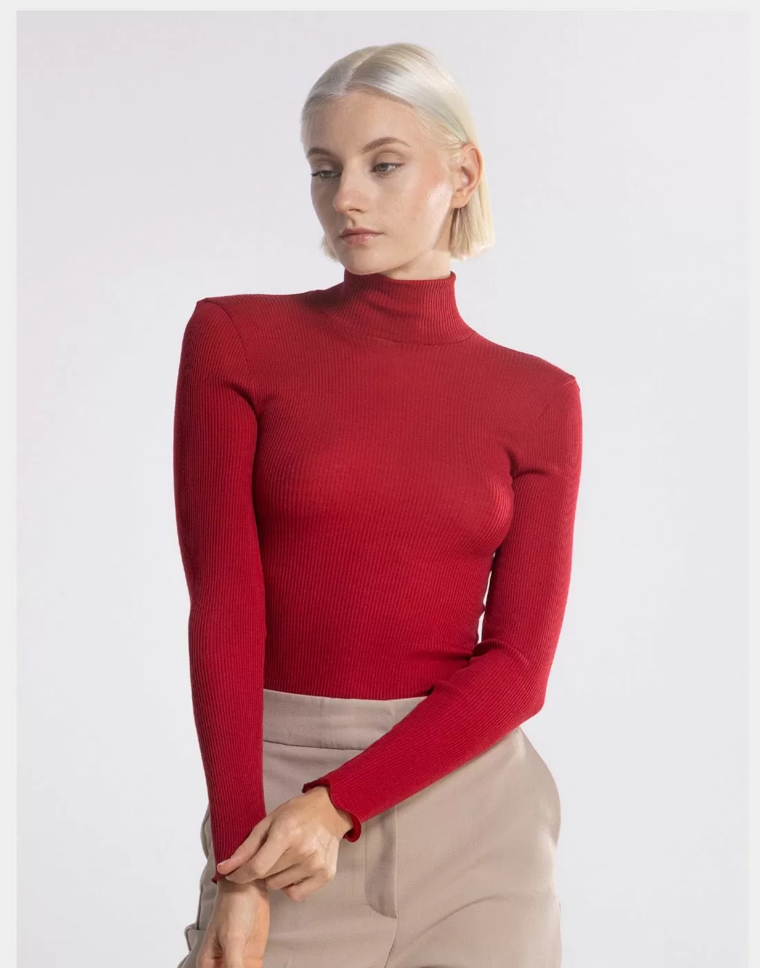 blond kvinne i rød høyhalset genser av ull og silke