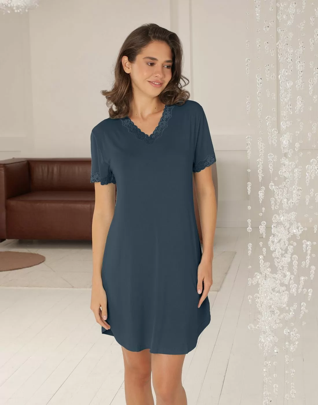 kvinne i blå kortermet nattkjole med blondekant